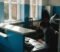 Practice manager reviewing CQC compliance documents at a GP surgery reception desk Practice manager reviewing CQC compliance documents at a GP surgery reception desk