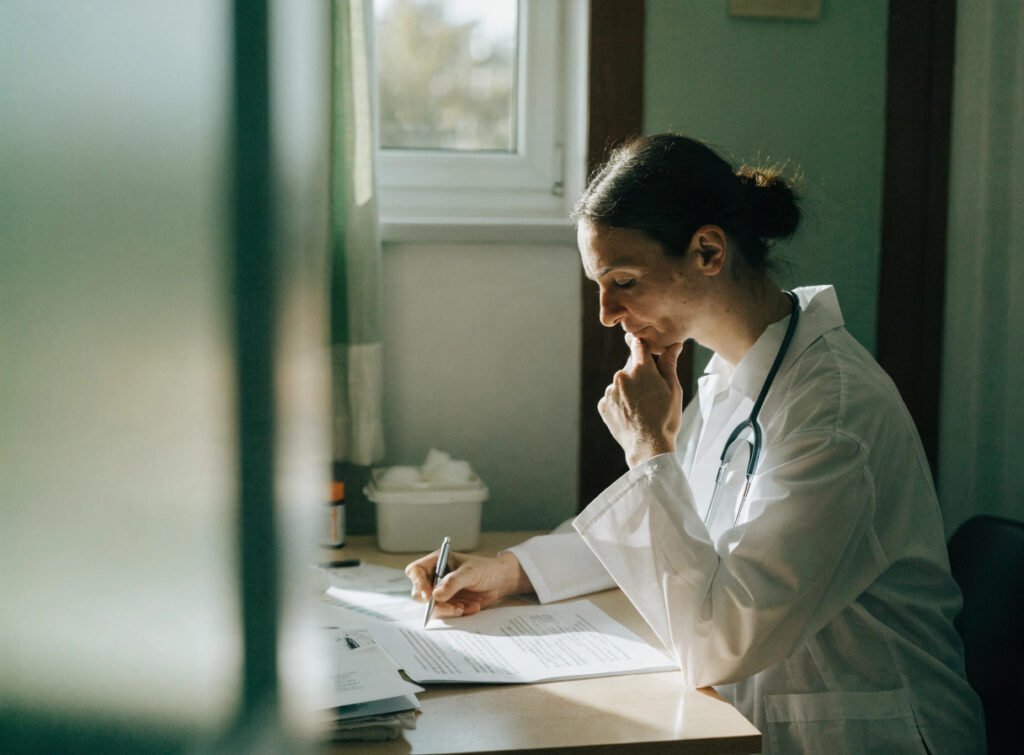 a gp reviewing their contract at a desk in a consultation room