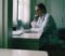 a gp working at a desk in a consultation room a gp working at a desk in a consultation room