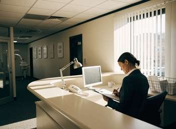 A dental practice reception area where a CQC registration application is being prepared during a practice sale