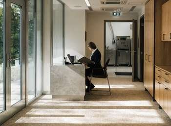 Dental practice manager reviewing CQC compliance documentation at reception desk