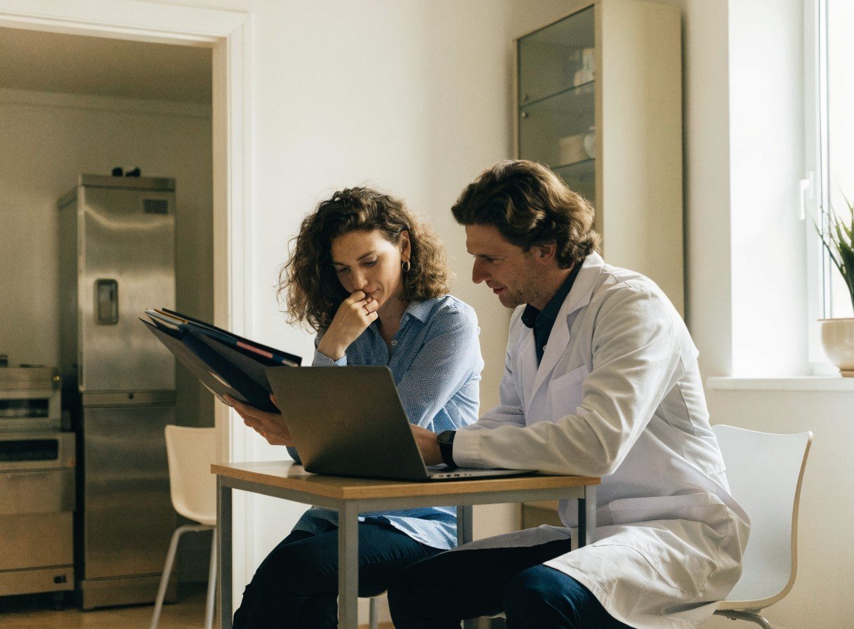 Dental practice manager and dentist reviewing CQC compliance documentation together