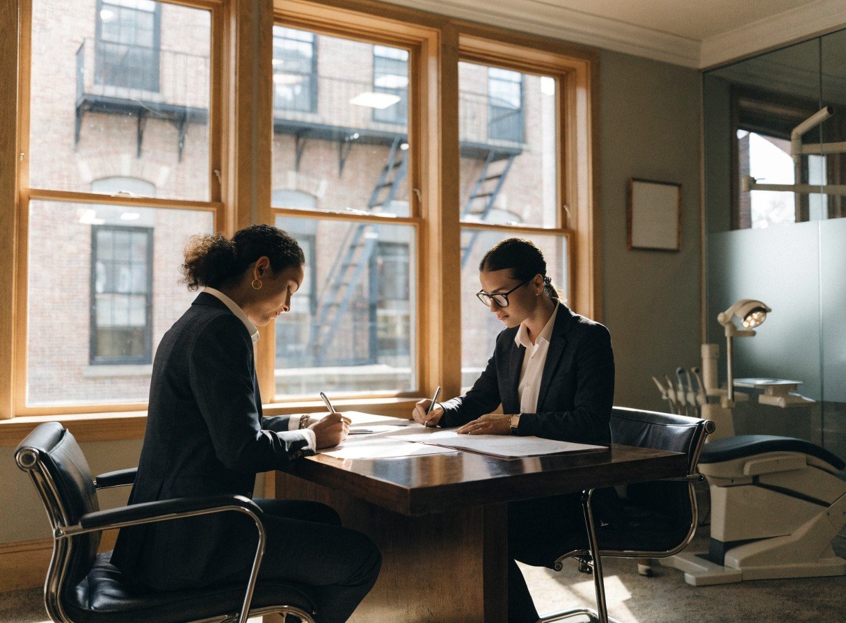 Dental practice directors completing CQC registration paperwork in an office setting
