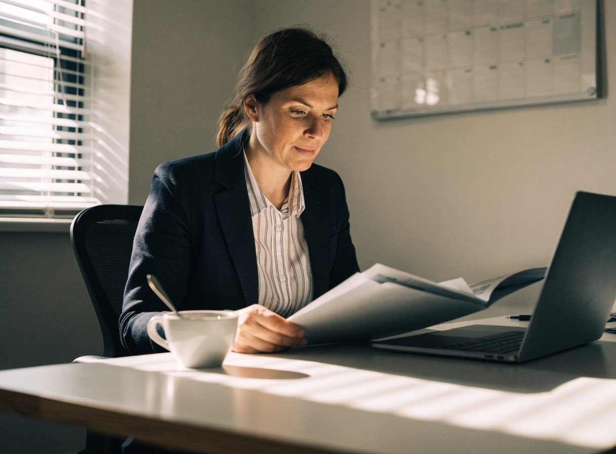 Dental practice registered manager reviewing staff compliance records in an office