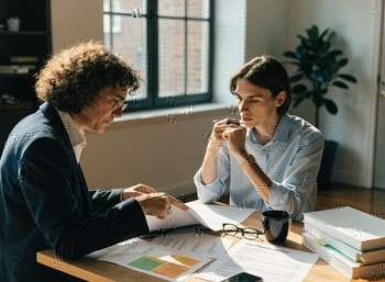 Solicitor and prospective buyer reviewing due diligence documents before a dental practice purchase