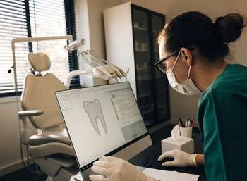 Dentist reviewing a patient treatment record on a practice computer system