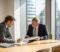 a business owner and a solicitor reviewing a company share register and corporate documents in a london meeting room A business owner and a solicitor reviewing a company share register and corporate documents in a London meeting room