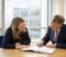 business owners and a solicitor reviewing a disclosure letter and bundle across a meeting table Business owners and a solicitor reviewing a disclosure letter and bundle across a meeting table