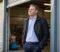 business owner standing in the doorway of their commercial premises while considering selling the business Business owner standing in the doorway of their commercial premises while considering selling the business