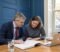 Business owners and their solicitor reviewing a share purchase agreement across a boardroom table
